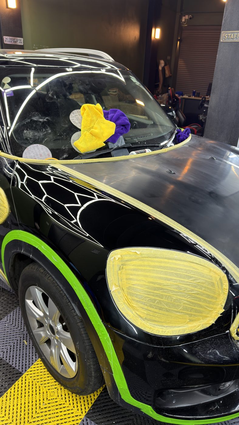 Mini Cooper front fender — paint correction compound residue, masking tape applied
